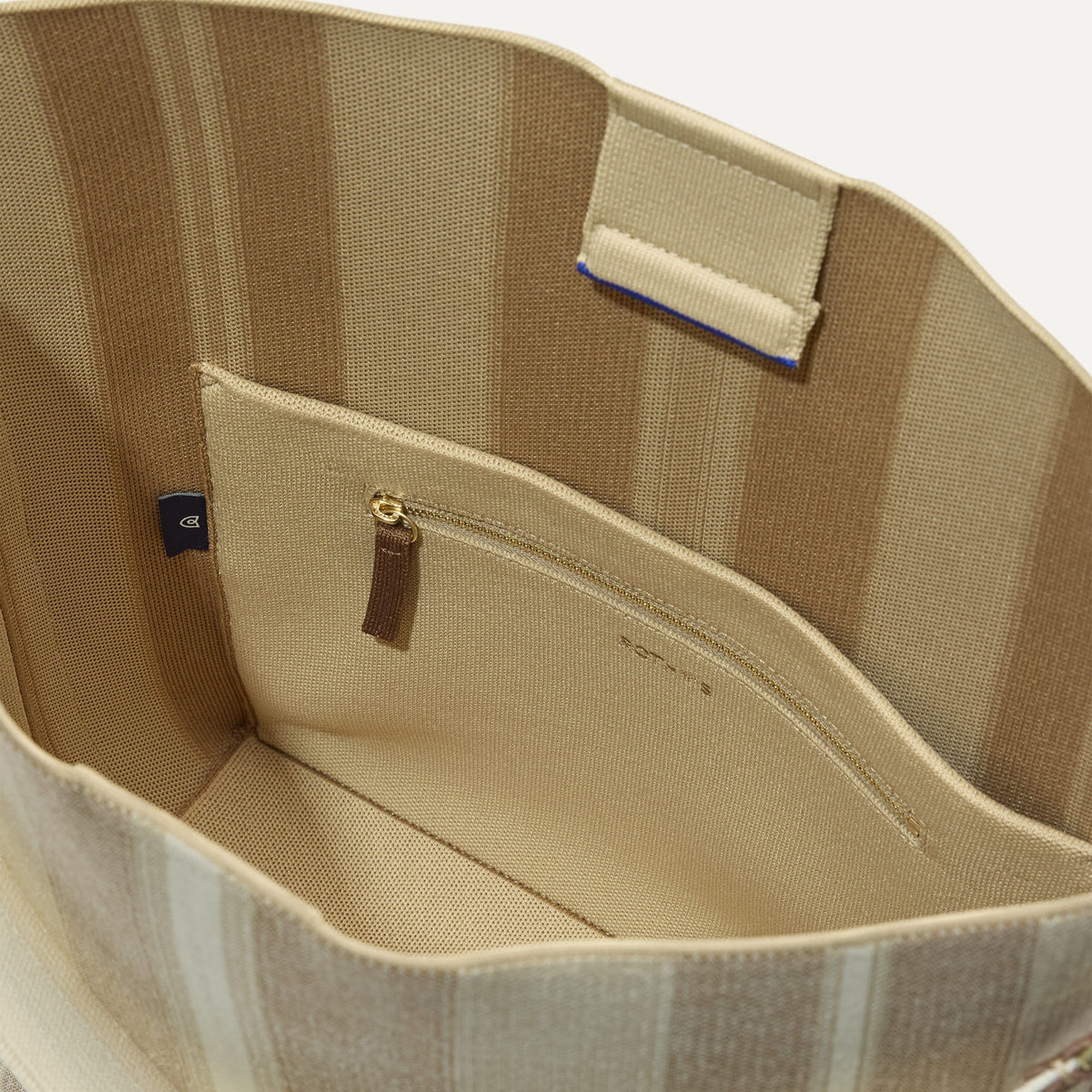 The Bucket Bag in Oat Latte close up of interior zipper pocket.