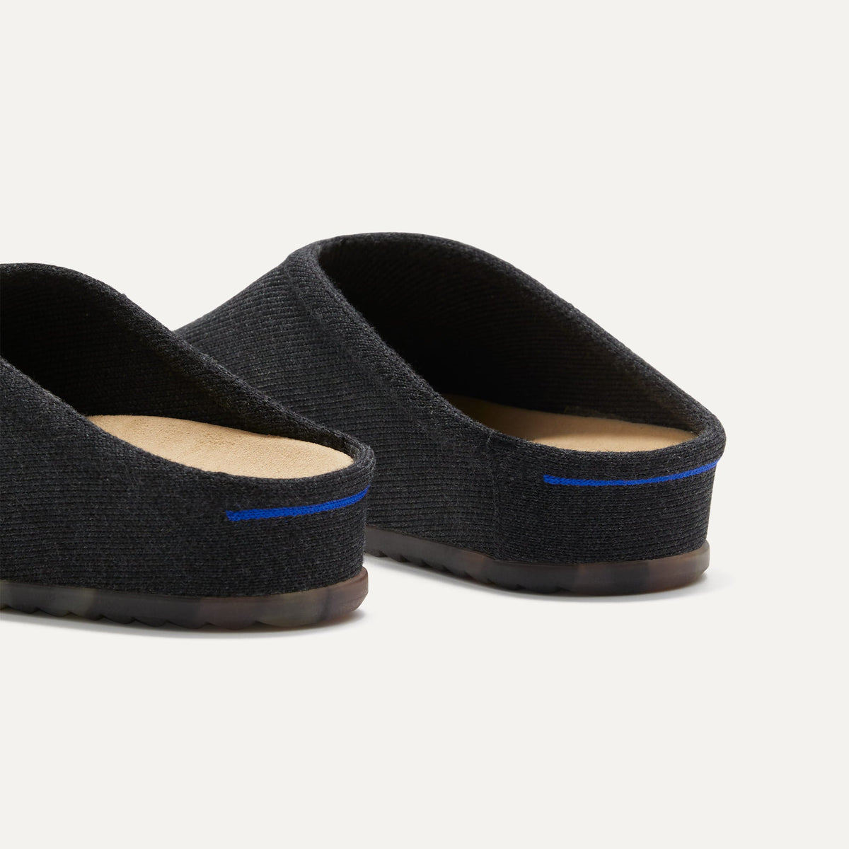 Close up of the heel of The Casual Clog in Soft Black, with Rothy's signature blue halo.