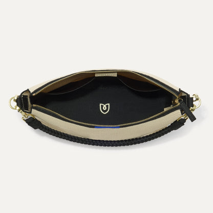 The Daily Crossbody in Black and White Raffia-Knit, shown from the top down, with zipper open and interior exposed.