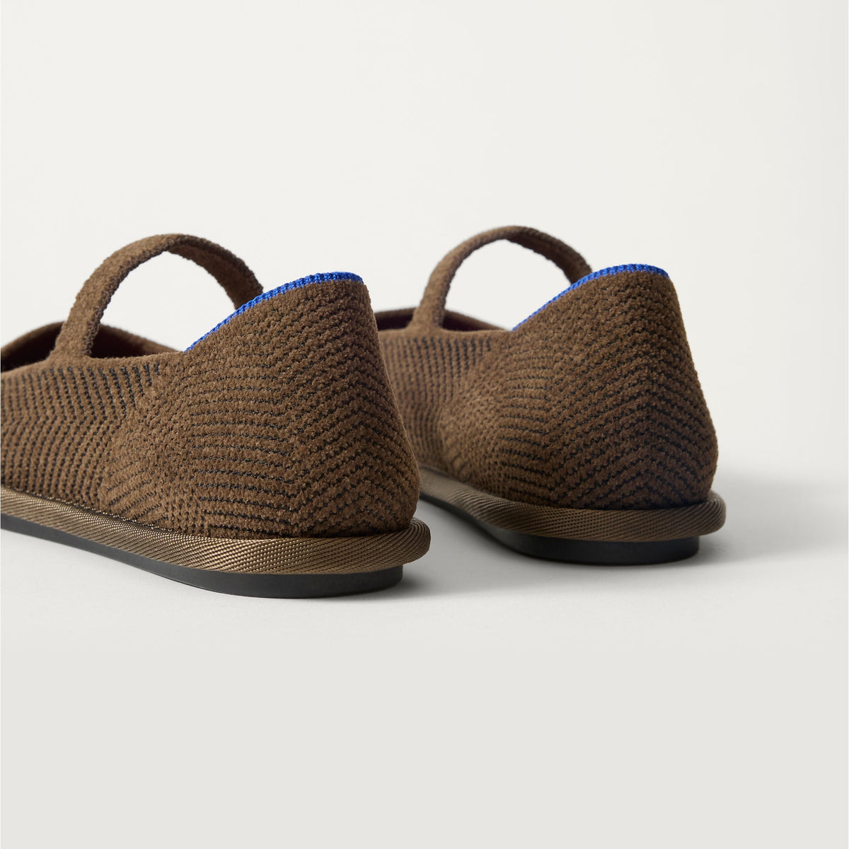 Close up of the heel of The Cruiser Mary Jane in ReVelvet Dark Herringbone, with Rothy's signature blue halo.