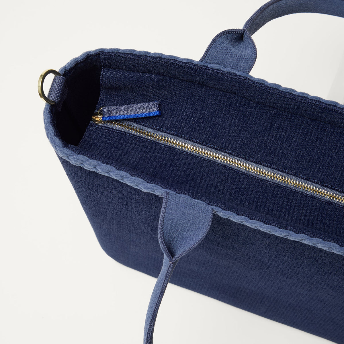 A close up of The Lightweight Zip Tote in ReVelvet Deep Navy focusing on the zip closure and handles.
